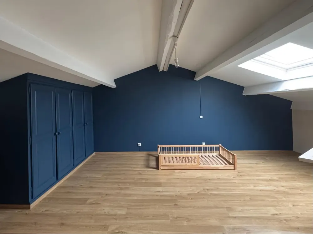 Pièce mansardée avec murs et placards peints en bleu profond